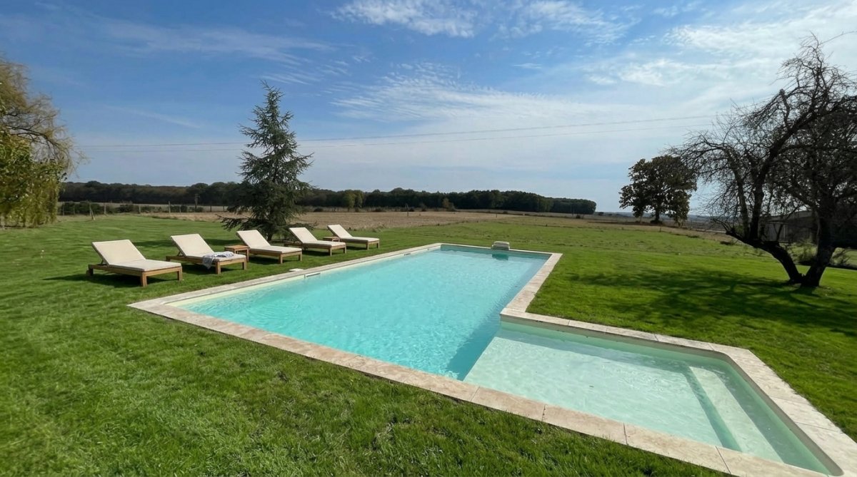 Espace détente avec piscine chauffée et chaises longues au Domaine des Ânes