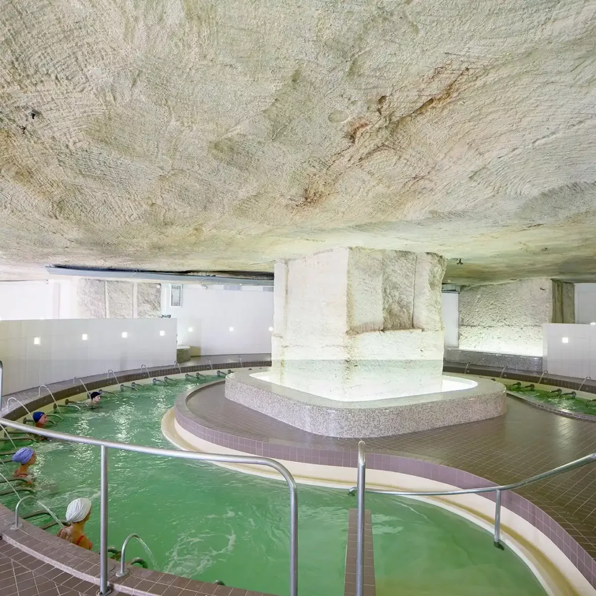 Curistes en soins dans le grand bassin d'eau thermale sous la roche troglodytique des Thermes de Jonzac