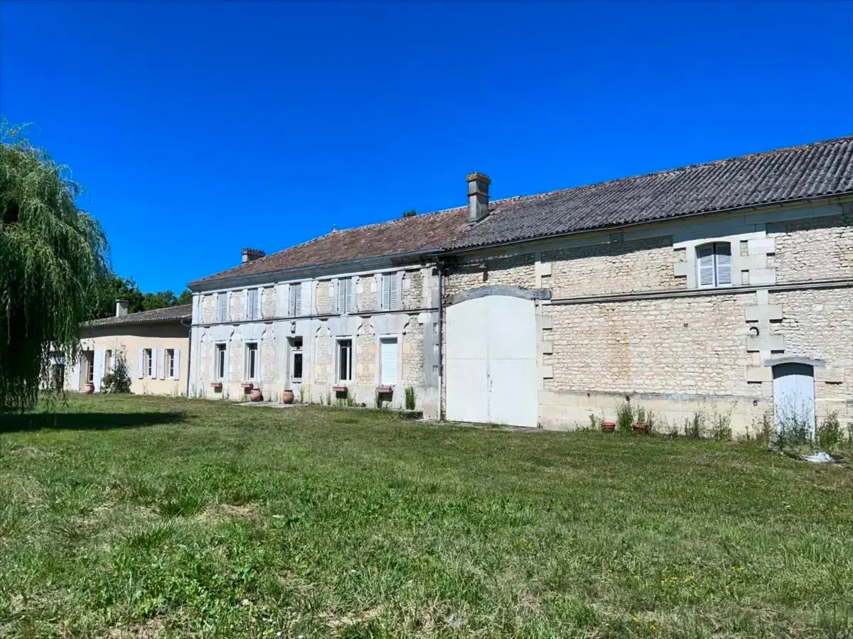 Façade en pierre de la maison de maître et de l'ancien corps de ferme avant les travaux de rénovation au Domaine des Ânes